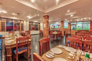 a dining room with wooden tables and chairs at Hotel Naveen Manali in Manāli