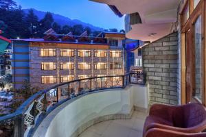 a balcony with a view of a building at Hotel Naveen Manali in Manāli