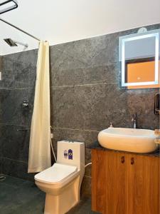 a bathroom with a toilet and a sink at Sunset Villa in Mysore