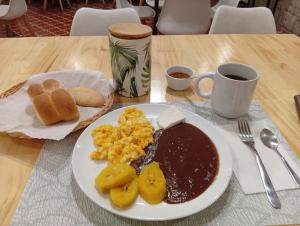 a plate of breakfast food on a wooden table at Lar Antiqua Hotel in Quetzaltenango