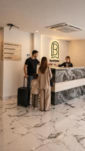 a man and a woman and two children standing in front of a counter at B Suites Boutique Hotel in Amman