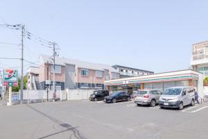 a parking lot with cars parked in front of a building at KEI HOUSE Yamato 101 in Yamato