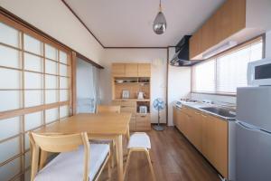 a kitchen with a wooden table and chairs in a room at KEI HOUSE Yamato 101 in Yamato