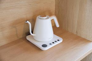 a white electric blender sitting on a wooden counter at KEI HOUSE Yamato 101 in Yamato