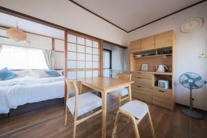 a bedroom with a bed and a desk and a table at KEI HOUSE Yamato 101 in Yamato