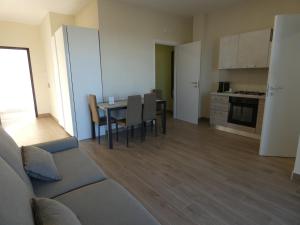 a living room with a couch and a table with chairs at Le Dune del Gargano in Zapponeta +48 photos