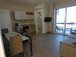 a kitchen and living room with a table and a couch at Le Dune del Gargano in Zapponeta