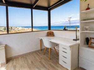 a room with a desk with a view of the ocean at Volcán de sal in Teguise