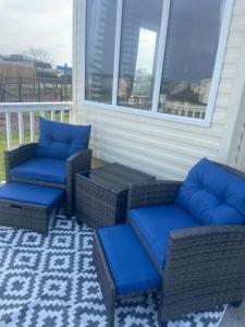 two wicker chairs and a table on a porch at Hudsons Pad Sandybay in Newbiggin-by-the-Sea
