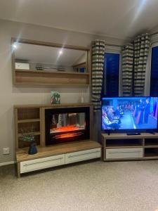 a living room with a television and a flat screen tv at Hudsons Pad Sandybay in Newbiggin-by-the-Sea