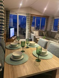 a living room with a table with plates and wine glasses at Hudsons Pad Sandybay in Newbiggin-by-the-Sea