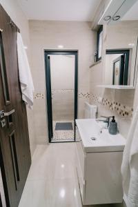 a bathroom with a sink and a shower with a mirror at WhiteBergHaus Colibita in Colibiţa +230 photos