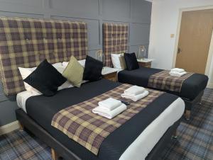 a hotel room with two beds with towels on them at Royal Dunkeld Hotel in Dunkeld