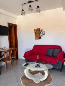 a living room with a red couch and a table at SeaBreeze Milos in Mytakas