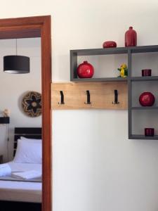 a room with a bed and a shelf with red items at SeaBreeze Milos in Mytakas