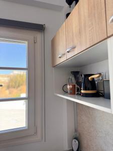 a kitchen with a counter top with a window at SeaBreeze Milos in Mytakas