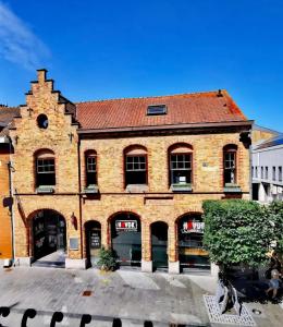 a large brick building with a red roof at City Loft I Fireplace I Free Parking I Garden Bath in Nieuwpoort