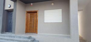 a building with a wooden door and a window at Maison salakta in Ksour Essaf