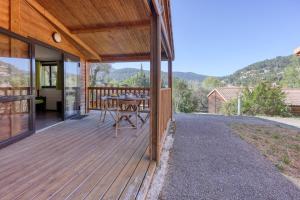 a wooden deck with a table and chairs on it at L'Oasis provençale - Joli chalet avec terrasse in Solliès-Toucas