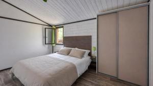 a bedroom with a large bed and a window at L'Oasis provençale - Joli chalet avec terrasse in Solliès-Toucas +8 photos