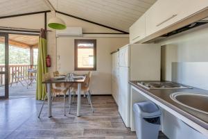 a kitchen with a table and a dining room at L'Oasis provençale - Joli chalet avec terrasse in Solliès-Toucas