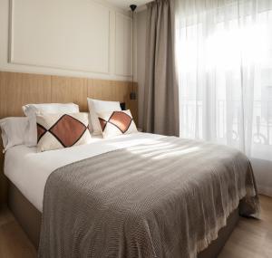 a bedroom with a large white bed with a window at Feelathome Cortes in Madrid