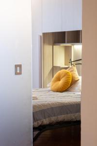 a bedroom with a bed with a yellow pillow on it at Rjgal Apartment B&B - Private Courtyard Florence Center in Florence