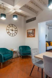 a waiting room with green chairs and a clock on the wall at Rjgal Apartment B&B - Private Courtyard Florence Center in Florence