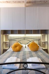 a bedroom with a bed with two yellow pillows at Rjgal Apartment B&B - Private Courtyard Florence Center in Florence