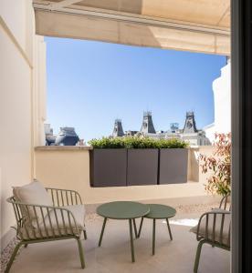 a patio with a table and chairs and a window at Feelathome Cortes in Madrid