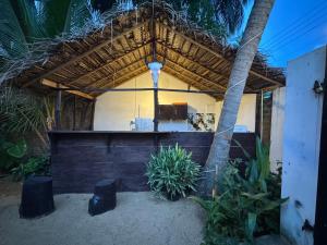 a house with a thatched roof and a room with plants at Moonlight surf hostel in Arugam Bay