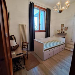 a bedroom with a bed and a desk and a window at Il Conte di Montechiaro Rural B&B in Sasso Marconi