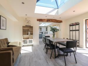 a kitchen and living room with a table and chairs at Gardeners Cottage in Oakham