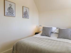 a bedroom with a bed and two pictures on the wall at Gardeners Cottage in Oakham