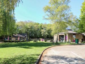 a park with picnic tables and a building at Gardeners Cottage in Oakham