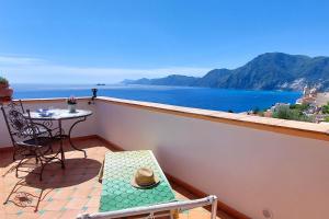 a balcony with a table and a view of the ocean at La dimora degli Dei in Praiano