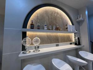 a bathroom with a shelf with wine glasses on it at Jupiter Hostel in Ban Khlong Haeng