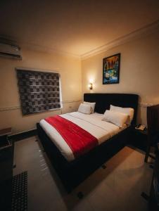 a bedroom with a large bed with a red blanket at MBL Hotel and Resort in Alakohia