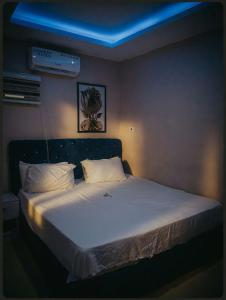 a bedroom with a large bed with a blue ceiling at MBL Hotel and Resort in Alakohia
