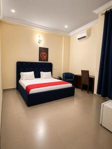 a bedroom with a bed and a desk and a chair at MBL Hotel and Resort in Alakohia