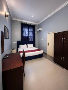 a bedroom with a bed and a desk in it at MBL Hotel and Resort in Alakohia
