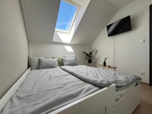 a white bed in a room with a window at Main Square Olive Studio in Trnava