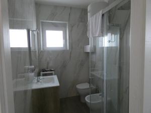 a bathroom with a sink and a toilet and a shower at Le Dune del Gargano in Zapponeta