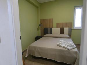 a bedroom with a bed with two towels on it at Le Dune del Gargano in Zapponeta