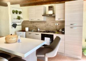 a kitchen with white cabinets and a table and chairs at Vacanza nella Natura in Punta Ala