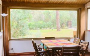 a table and chairs in a room with a large window at Vacanza nella Natura in Punta Ala