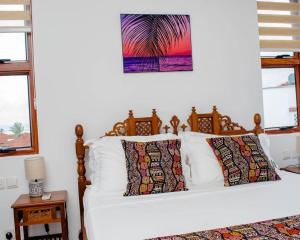 a bed with white sheets and pillows in a bedroom at WakaWaka SeaView Beach Condo in Mombasa