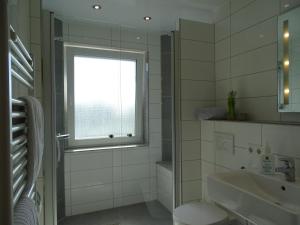 a white bathroom with a window and a sink at Das LENNI in Büren