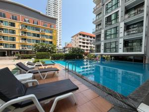 a swimming pool in a city with buildings at Neo Hotel Pattaya in Jomtien Beach