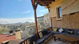 a balcony with a bench and a table on a building at Uchisar Cave House in Uçhisar